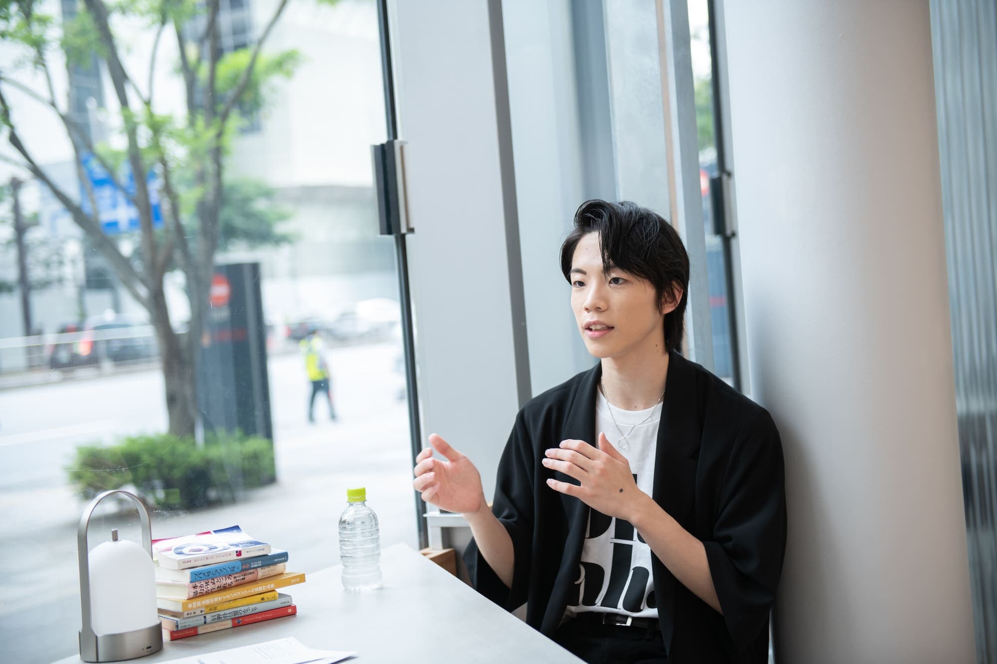 リクルートホールディングス運営のアートセンター「BUG」内にある「BUG Cafe」でインタビューに答える谷津凜勇さん