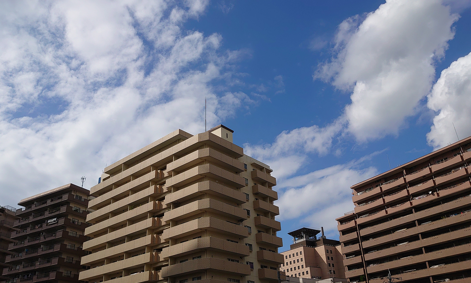 青空と複数のマンションの写真