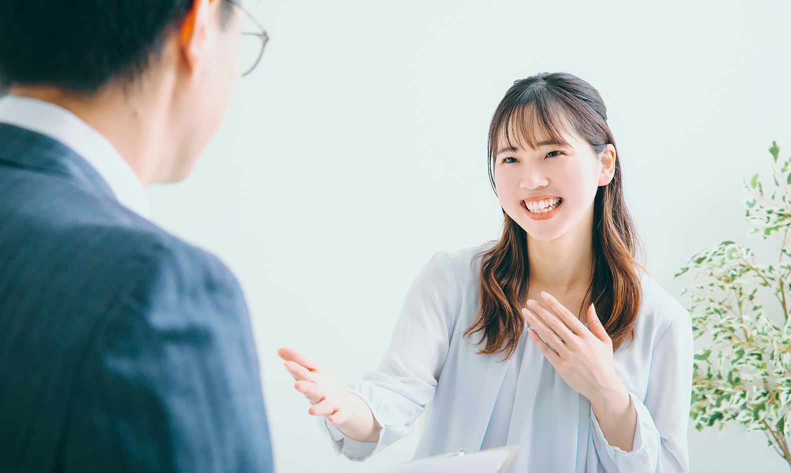 笑顔で話している女性と対峙している男性の写真